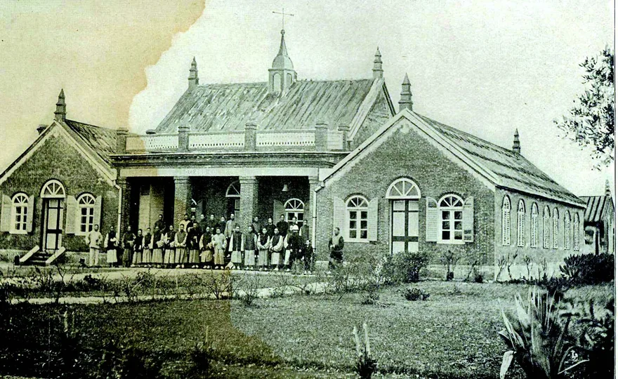 落成於 1882 年仲夏,清末俗稱大學的「牛津學堂」,照片右方馬偕博士牽著偕叡廉。攝於1890 年 6 月 26 日。