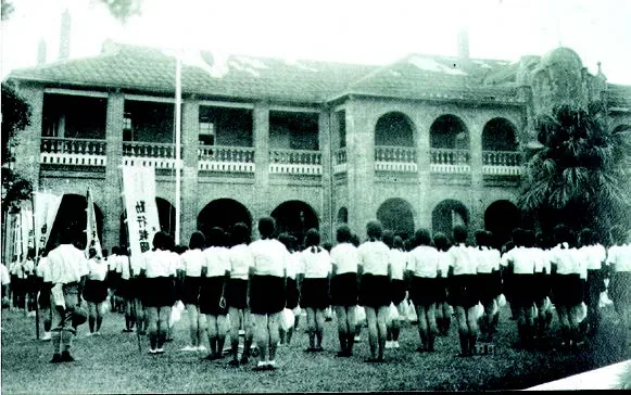 淡水高女的學生在女學校校舍前集 合,將進行「勤行報國」前往淡水海軍墓園為英烈掃墓。